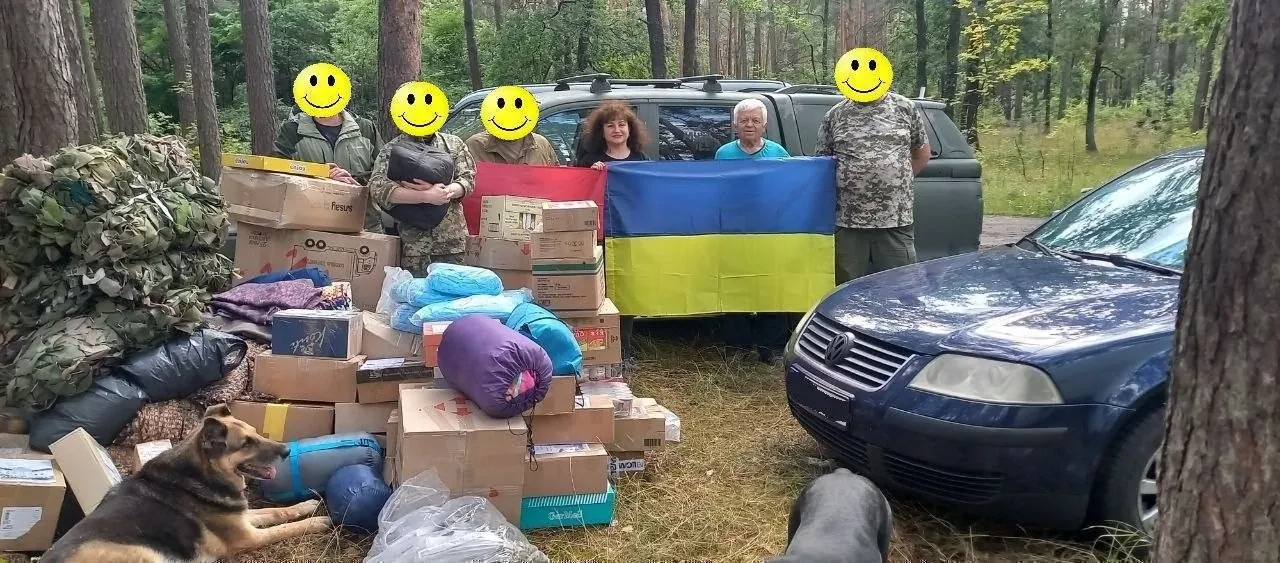 Передача допомоги: коробки, спальники та прапор України в лісі